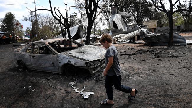 Eight year-old Jarrod McInnes walks next to the remains of a house that his family was about to buy and was destroyed by the Black Summer bushfires in Rappville, NSW, Thursday, October 10, 2019. Picture: Dan Peled.