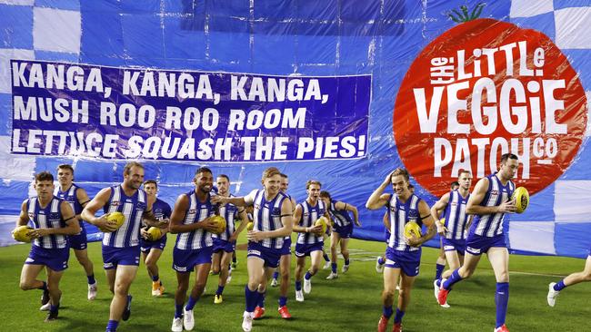 MELBOURNE, AUSTRALIA - MAY 08: North Melbourne players run through their banner during the 2021 AFL Round 08 match between the North Melbourne Kangaroos and the Collingwood Magpies at Marvel Stadium on May 08, 2021 in Melbourne, Australia. (Photo by Dylan Burns/AFL Photos via Getty Images)