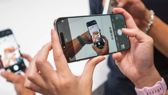 A woman takes a video of the new iPhone 16 Pro after Apple's "It's Glowtime" event in Cupertino, California, September 9, 2024. Apple on Monday announced a new iPhone built for generative artificial intelligence as it seeks to boost sales and show it is keeping up in the technology race. (Photo by Nic Coury / AFP)