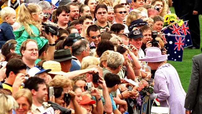 Queen Elizabeth II, accepts flowers during her 'meet the people walk' at Roma Street Parklands.