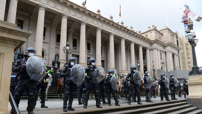 Police form a cordon in front of Parliament House in Melbourne after violent protests against mandatory vaccinations for workers on building sites. Picture: NCA NewsWire / Andrew Henshaw