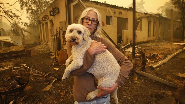 Mallacoota Fires. Jann Gilbert with her dog Ollie visits the site of her burnt out unit. Picture: David Caird