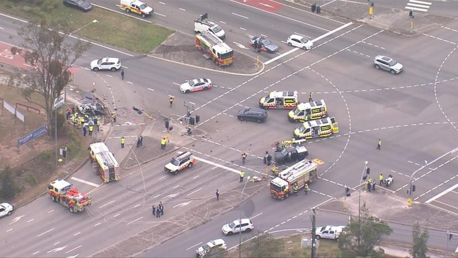 Emergency services rushed to the scene where one man had to be cut from a vehicle by Fire and Rescue crews. Picture: 7News