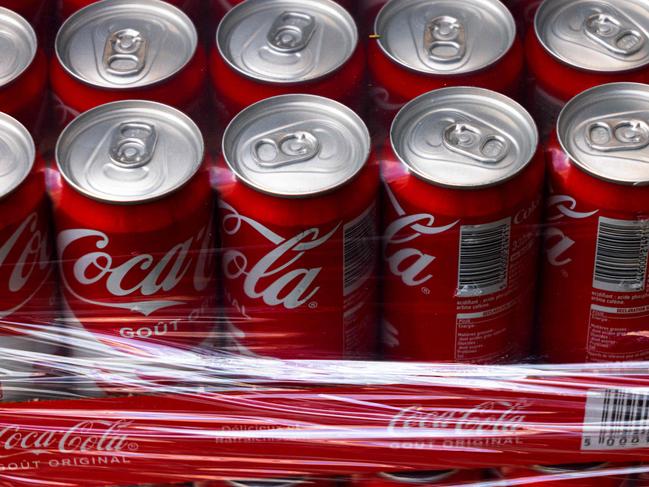 This photograph shows Coca-Cola soft drink cans wrapped in plastic in Paris on September 16, 2024. (Photo by JOEL SAGET / AFP)