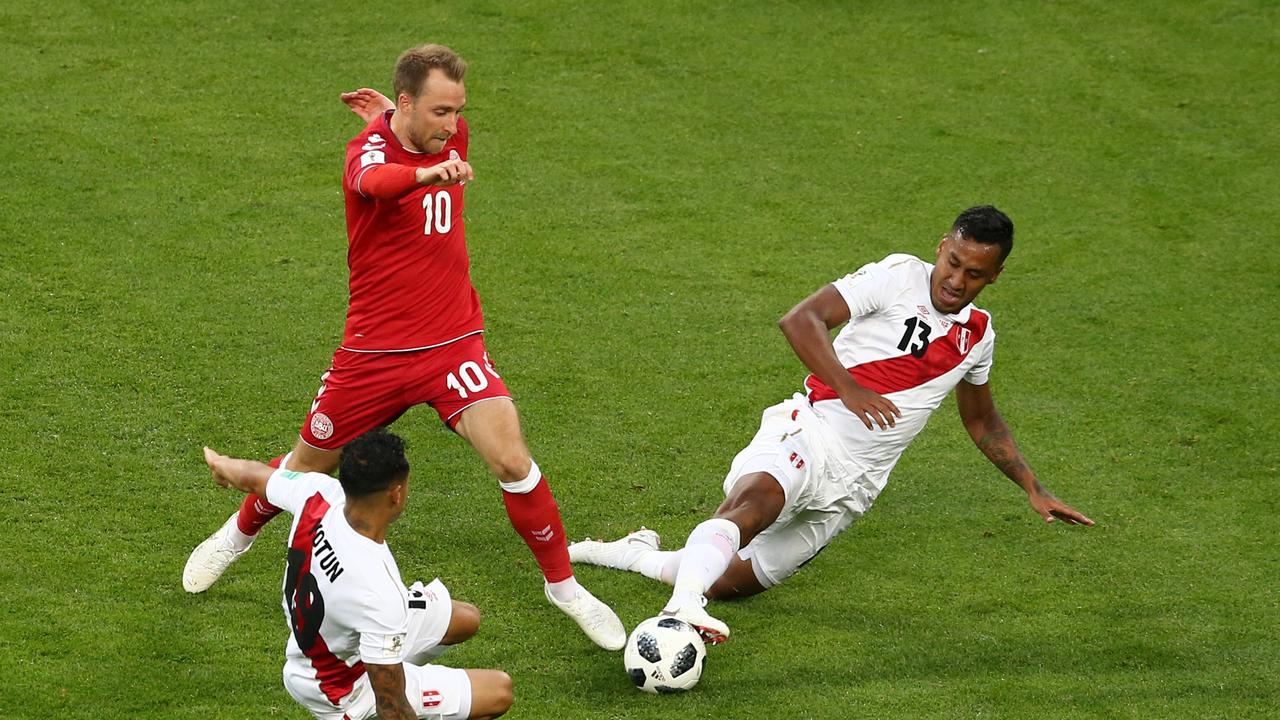 Yoshimar Yotun and Renato Tapia of Peru challenge Christian Eriksen of Denmark