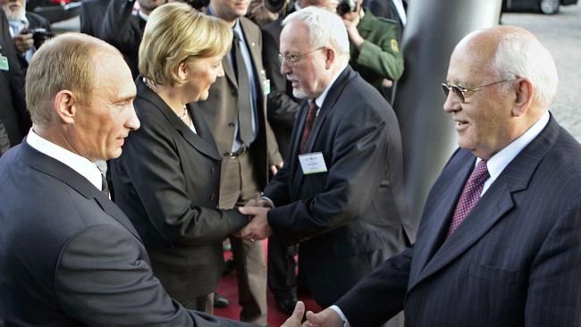 Vladimir Putin, left, shakes hands with former Soviet Union president Mikhail Gorbachev, as German chancellor Angela Merkel shakes hands with former East German PM Lothar de Maiziere in 2006. Picture: AFP