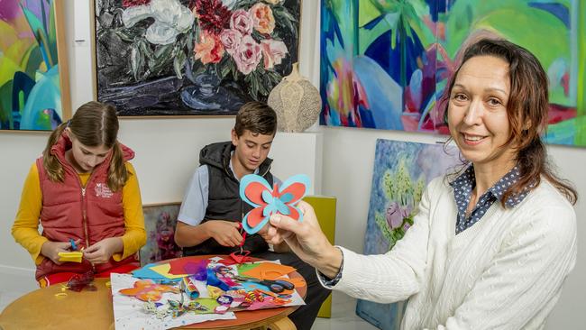Artist Mariya Todorova teaching Issy van Drongelen, 11, and Alexander Nott, 13, how to create paper butterflies for the Main Beach Flower Festival. Picture: Jerad Williams