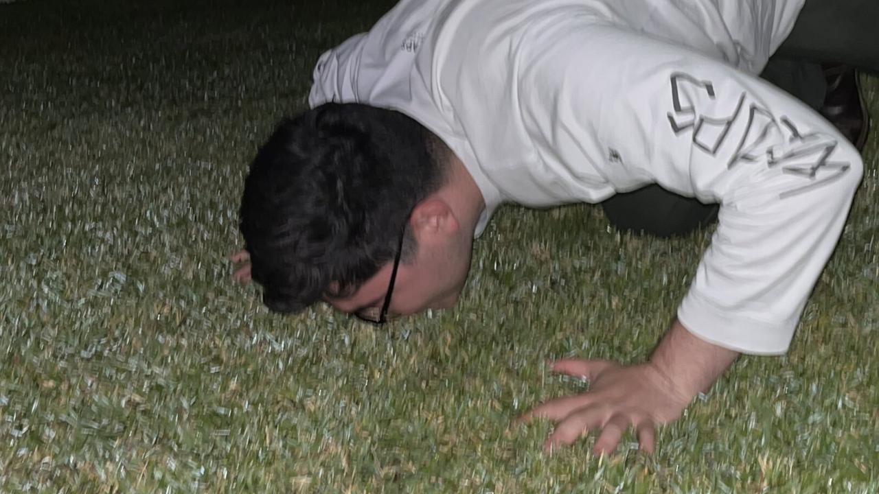 Drew Pavlou kisses the ground upon his return home to Australia. Picture: @DrewPavlou / Twitter