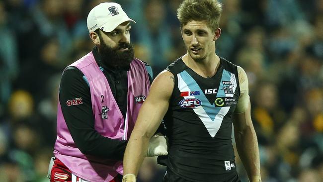 Hamish Hartlett is tended to by a Port Adelaide trainer after a heavy head knock. Picture: Sarah Reed