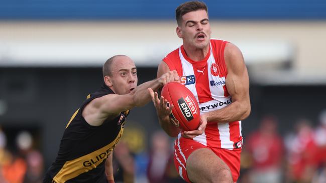 SANFL Round-6 Glenelg v North Adelaide Alex Martini gets his fist to the ball to spoil Noah Casalini Picture: Cory Sutton