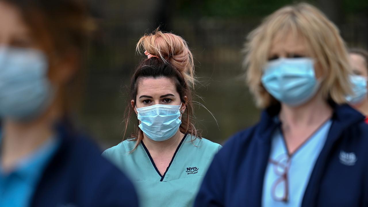 Staff gather outside a hospital for a minute’s silence to reflect on the anniversary of the day the UK entered its first lockdown. Picture: Jeff J Mitchell/Getty Images