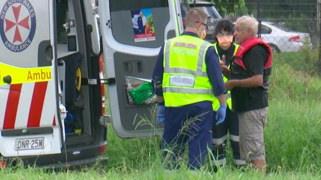 Paramedics attend to a man at the scene. Picture: TNV