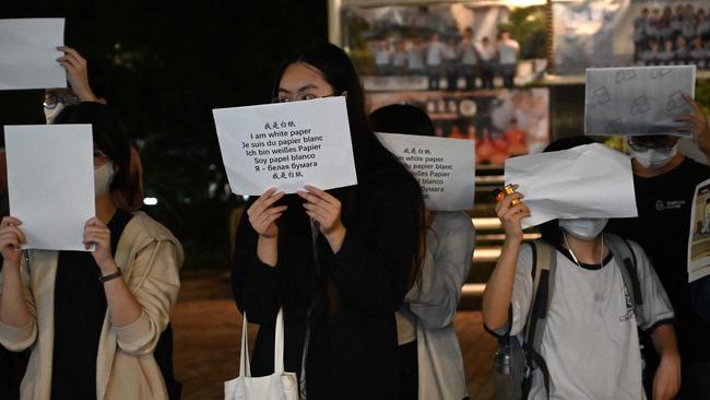 Protesters hold up placards including blank white sheets of paper in an outpouring of anger. Picture: AFP.