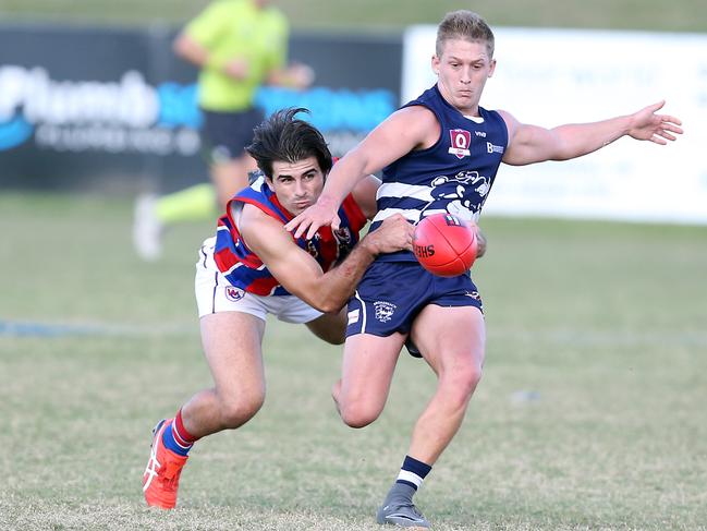 Round 8 QAFL game between Broadbeach Cats and Wilston Grange at Subaru Oval. Photo of Liam Nelson kicking under pressure from Lliam Molan. Photo by Richard Gosling