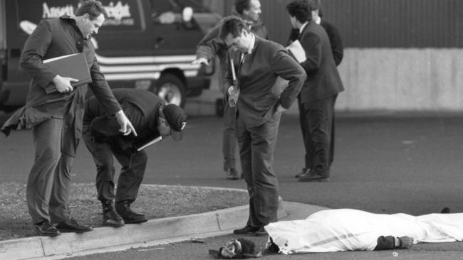 Police stand over the body of Norman Leung Lee who was shot dead during a failed armed robbery at Melbourne Airport.