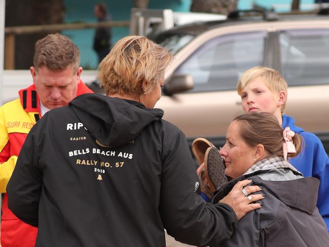 Carol Chaffer, (right) and her son Sam, talk to friends after helping in the rescue of the surfer at Collaroy Beach. Picture John Grainger