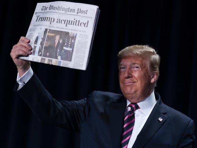 US President Donald Trump holds up a newspaper during the 68th annual National Prayer Breakfast. Picture: AP