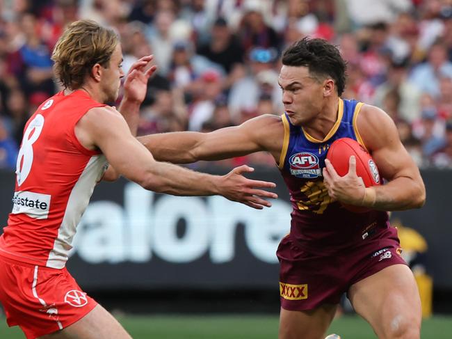 MELBOURNE , AUSTRALIA. September 28, 2024. AFL Grand Final between the Brisbane Lions and Sydney Swans at the MCG. Cam Rayner of the Brisbane Lions uses his strength to fend off a tackle from Sydney Swan James Rowbottom. Picture: David Caird