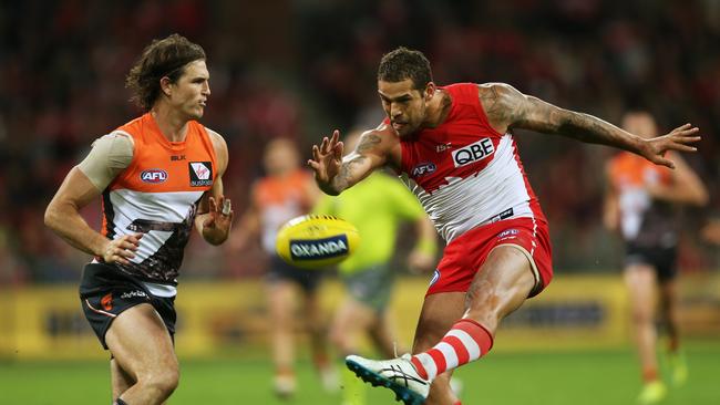 Sydney's Lance Franklin gets a kick away under pressure from GWS Giant Phil Davis. Picture: Toby Zerna