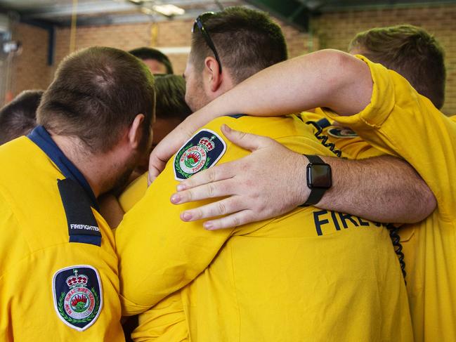 SYDNEY, AUSTRALIA - DECEMBER 22: Members of the Horsley Park Rural Fire Brigade have a group hug on December 22, 2019 in Sydney, Australia. The men died when their truck overturned near the town of Buxton late on Thursday when a tree fell into their path. A catastrophic fire danger warning has been issued for the greater Sydney region, the Illawarra and southern ranges as hot, windy conditions continue to hamper firefighting efforts across NSW. NSW Premier Gladys Berejiklian declared a state of emergency on Thursday, the second state of emergency declared in NSW since the start of the bushfire season. (Photo by Jenny Evans/Getty Images)