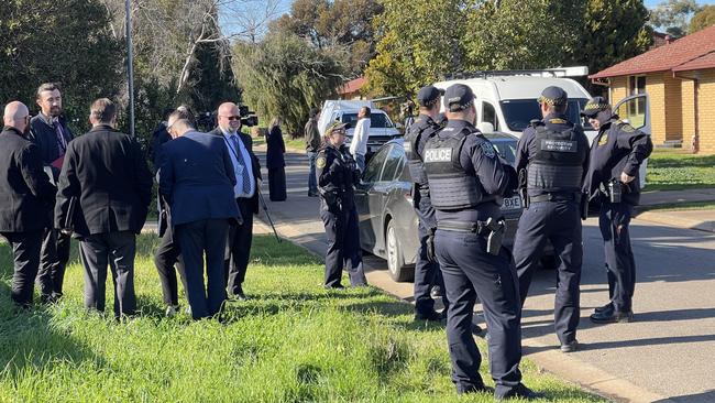 Detectives and police in the Munno Para street Charlie lived on. Picture: Russell Millard