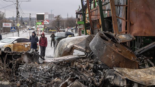 People walked past a destroyed Russian military vehicle on March 3 in Irpin, Ukraine. Picture: Chris McGrath/Getty Images