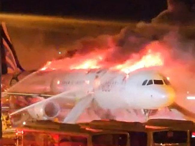 Fire authorities work to extinguish a fire that broke out on an Air Busan passenger plane at Gimhae International Airport in Busan on January 28, 2025. The tail of a passenger aircraft caught fire at an international airport in South Korea's second-largest city on January 28, forcing the evacuation of 176 people on board, Yonhap news agency reported. (Photo by YONHAP / AFP) / - South Korea OUT / NO ARCHIVES -  RESTRICTED TO SUBSCRIPTION USE