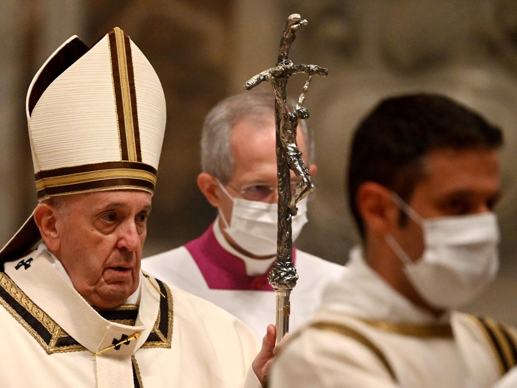 Pope Francis (L) arrives to lead a Christmas Eve mass to mark the nativity of Jesus Christ at St Peter's basilica in the Vatican amidst the COVID-19 pandemic. Picture: AFP