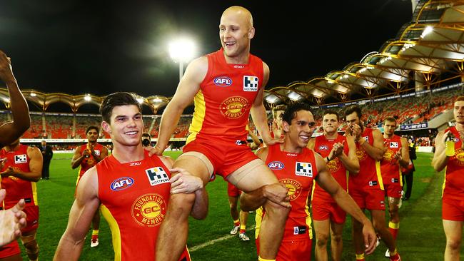 O'Meara (left) and Harley Bennell (right) chair Gary Ablett Jnr off after his 250th game.