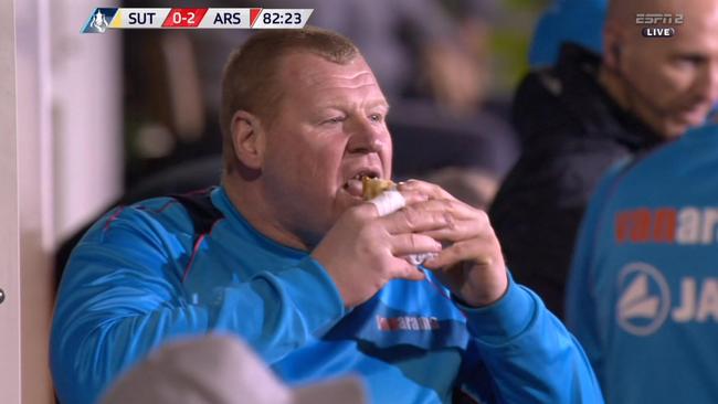 Sutton goalkeeper Wayne Shaw eating a pie.