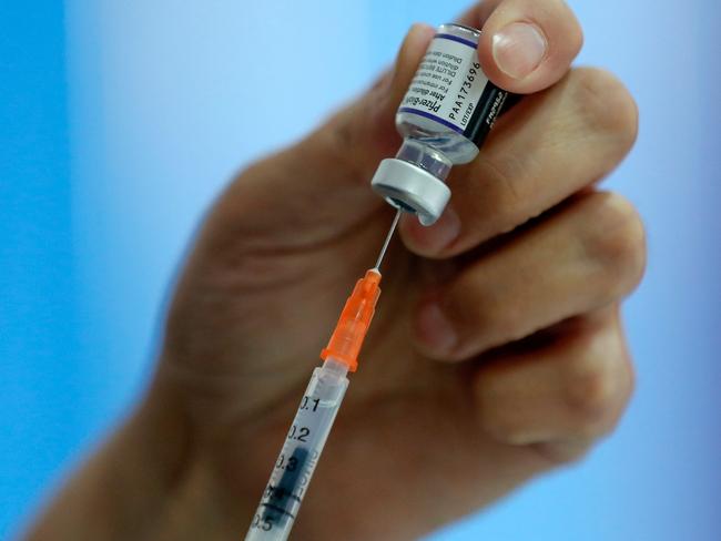 A health worker prepares a dose of the Pfizer-BioNTech vaccine against COVID-19 at a vaccination center in Santiago, on January 20, 2022. - Chile registered this Thursday a new record of daily infections, with 12,500 new infected, the highest number in the entire pandemic, in one of the countries with the highest percentage of its population vaccinated and that this Thursday began to apply the fourth dose to health personnel. (Photo by JAVIER TORRES / AFP)