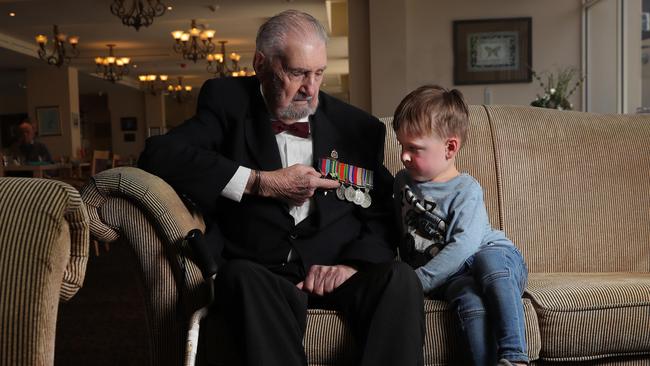 John Macdonald talks about his medals from his time in the Pacific with great grandson Connor Evans, 4. Picture Glenn Hampson