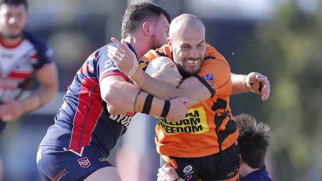 Michael Oldfield (centre) of the Southport Tigers is tackled by Reece Summer (left) and Aaron Booth of Runaway Bay Seagulls during the Rugby League Gold Coast minor semi final played at Owen Park, Southport, Gold Coast, Sunday, August, 28, 2022. Photo: Regi Varghese