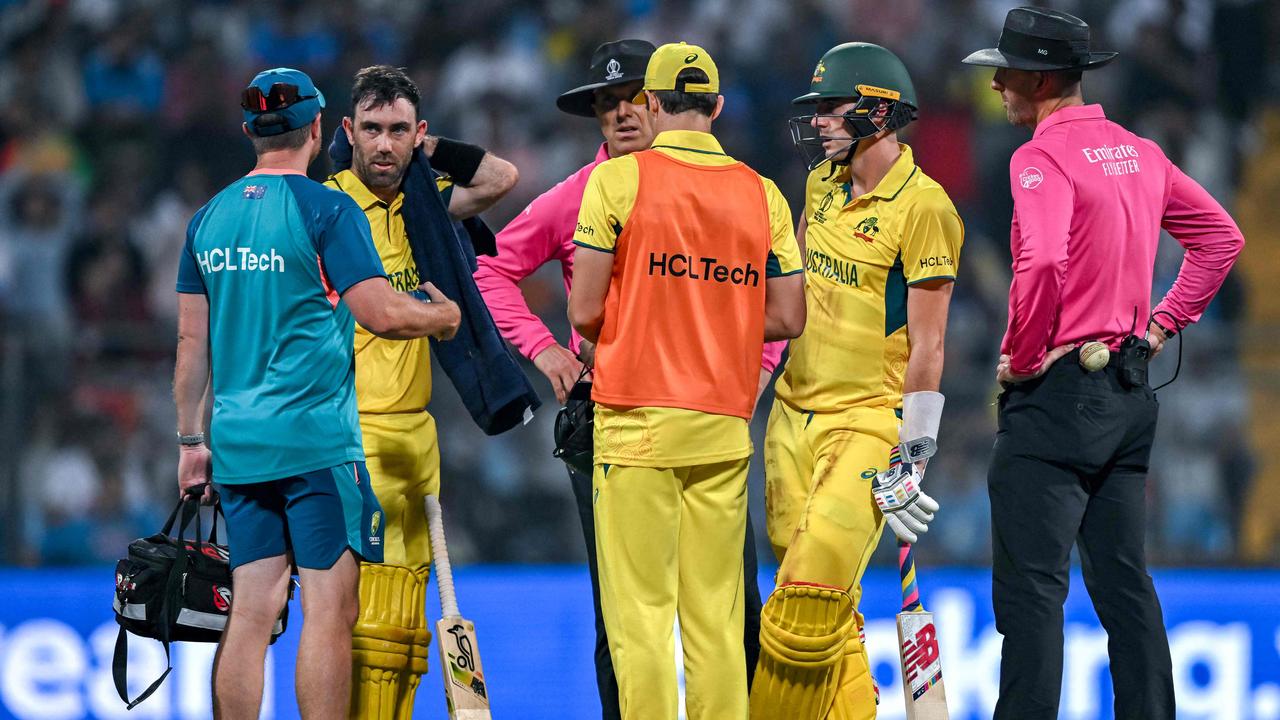 Australia's Glenn Maxwell (2L) speaks with the Australian team physio. Picture: AFP