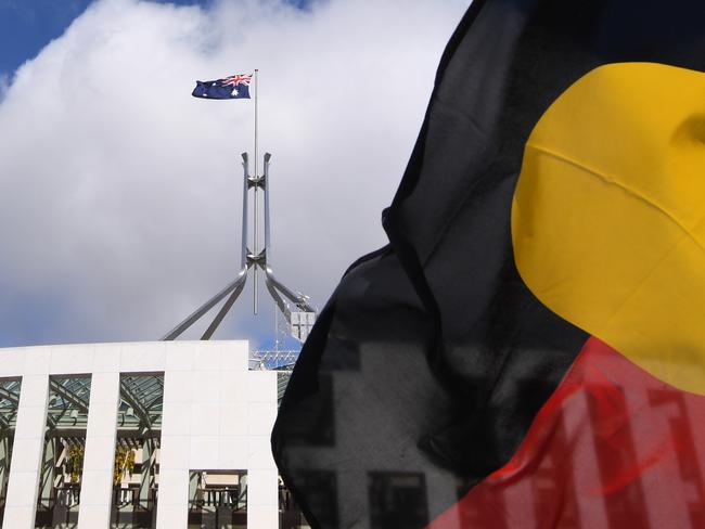 Australian Parliament House is seen through an Aboriginal flag in Canberra, Tuesday, September 5, 2017. (AAP Image/Lukas Coch) NO ARCHIVING