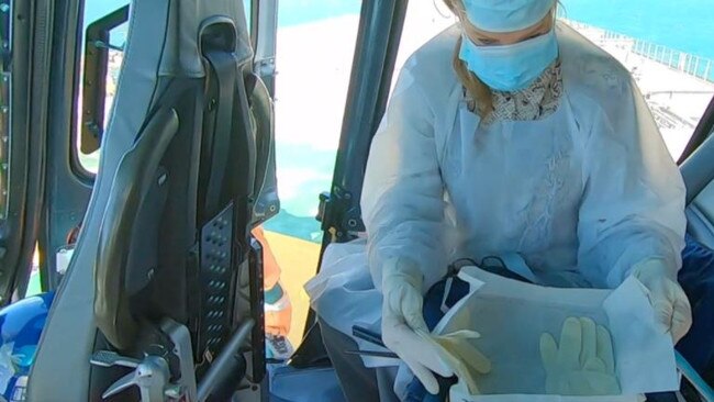 Elizabeth McIntosh putting on PPE in the helicopter. Picture: supplied