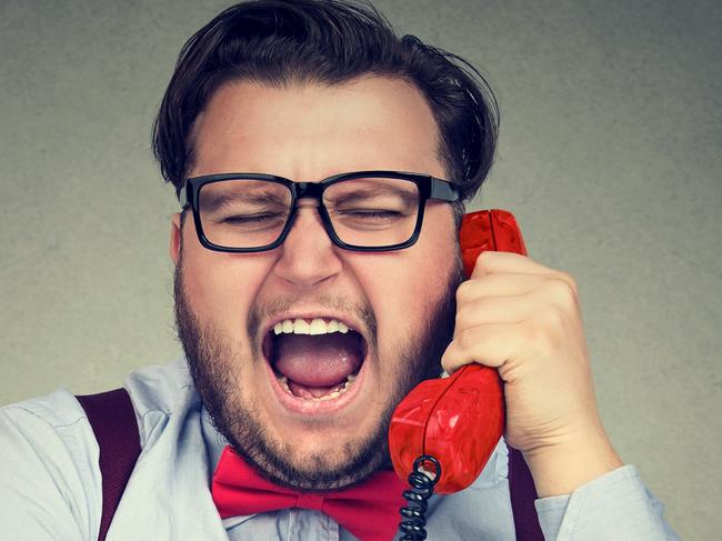 Chubby formal man talking on phone and shouting while working in bank. istock image