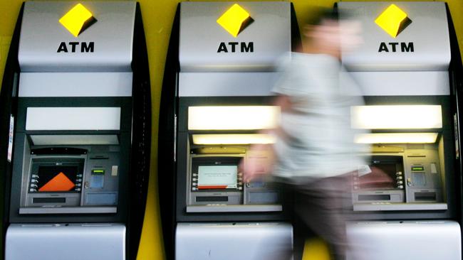 A pedestrian walks past Automated Teller Machines (ATM's) of the Commonwealth Bank of Australia in Sydney, Australia, on Tuesday, Feb. 12, 2008. Photographer: Ian Waldie/Bloomberg News