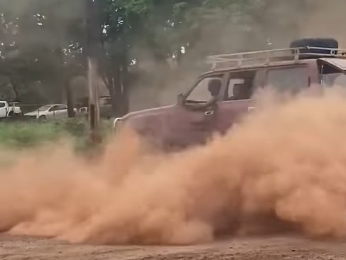 A scene from the videos showing the LandCruiser chucking a donut, spraying red dirt and dust all around, while it is being followed by a police vehicle. Video: Indy KnighttNew (Facebook)