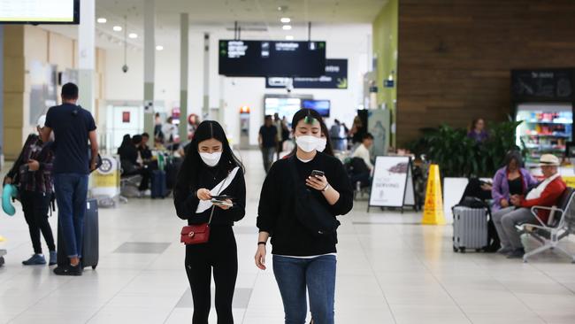 Tourists wearing masks at Gold Coast Airport as the Coronavirus epidemic causes havoc with peoples travel plans. . Picture Glenn Hampson