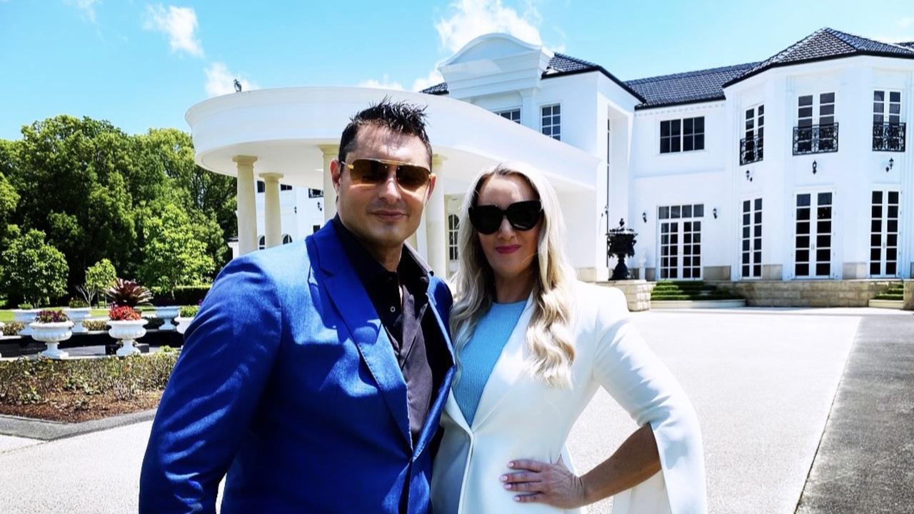 The couple outside a Tallebudgera mansion they took to auction last year