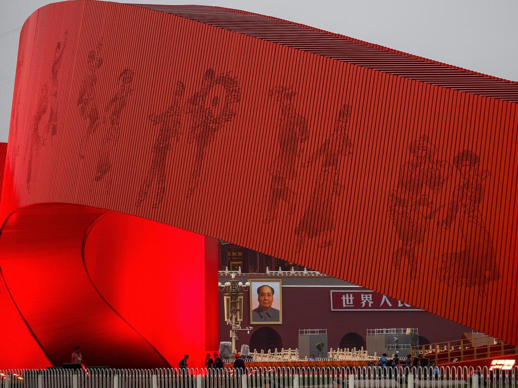 Workers set up near a red ribbon decoration on Tiananmen Square. Picture: AP