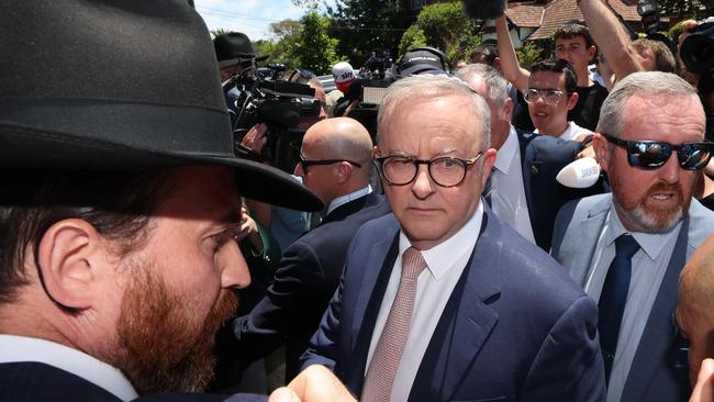 Prime Minister Anthony Albanese visits the fire damaged Adass Israel Synagogue in Ripponlea. The PM is looked concerned at the crowd crush while protected by his security team leaving from a side door of the Synagogue still wearing the Kippah after a meeting with community leaders.                  Picture: David Caird