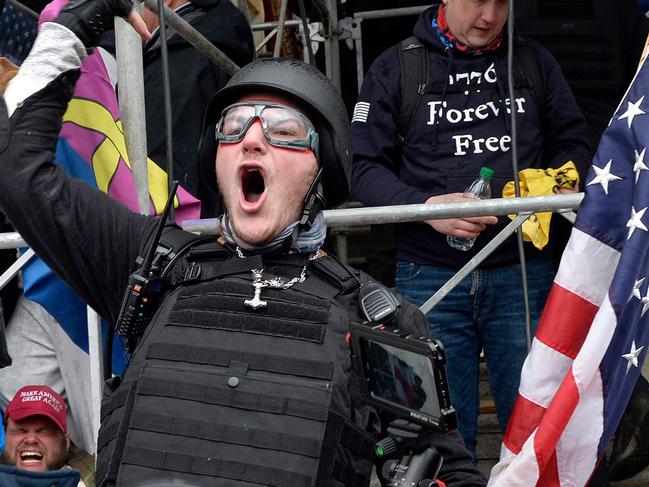 TOPSHOT - A man calls on people to raid the building as Trump supporters clash with police and security forces as they try to storm the US Capitol in Washington D.C on January 6, 2021. - Demonstrators breeched security and entered the Capitol as Congress debated the a 2020 presidential election Electoral Vote Certification. (Photo by Joseph Prezioso / AFP)