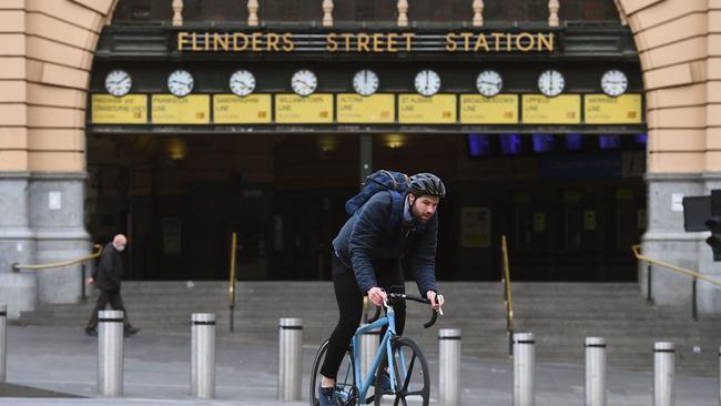 A cyclist passes a near-deserted Flinder St Station last week. Picture: William West/AFP