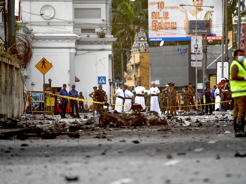  Sri Lankan priests look at the debris of a car after it exploded when police tried to defuse a bomb near St Anthony's Shrine. Picture: AFP