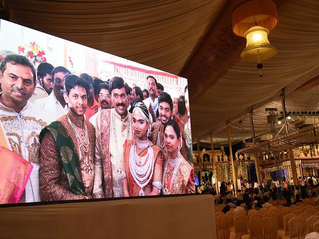 Indian mining tycoon, Gali Janardhan Reddy, (C) is seen on a big screen as he poses with his daughter Bramhani (2R) and son-in-law, Rajeev Reddy (2L) during their wedding. Picture: AP