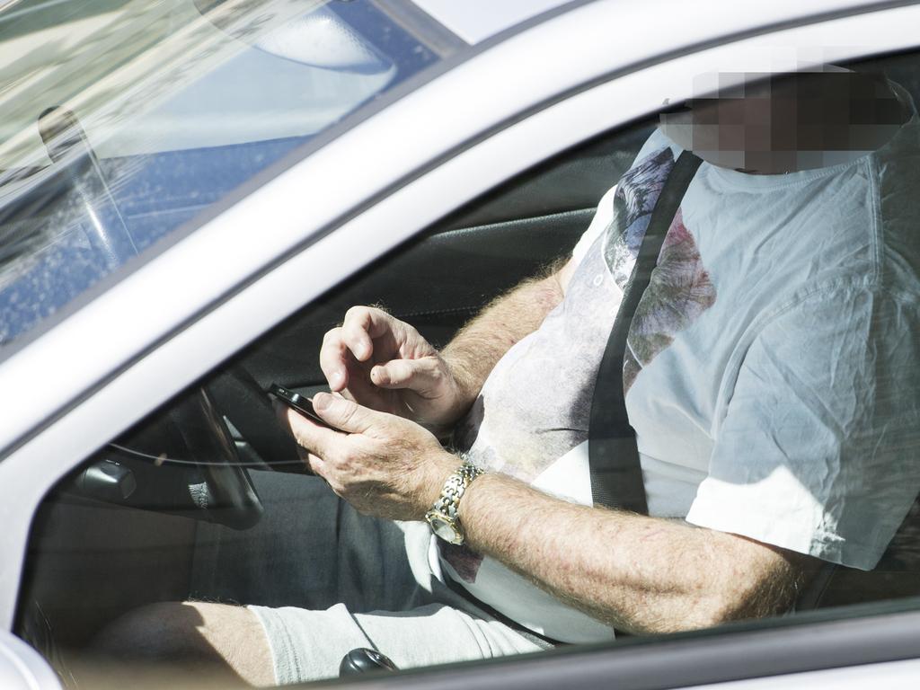 A driver is caught using his mobile phone on the corner of Wellington and Barrack St, Perth.  After using the phone in his hands, the driver then places the phone on his lap, which is also against the road rules.
