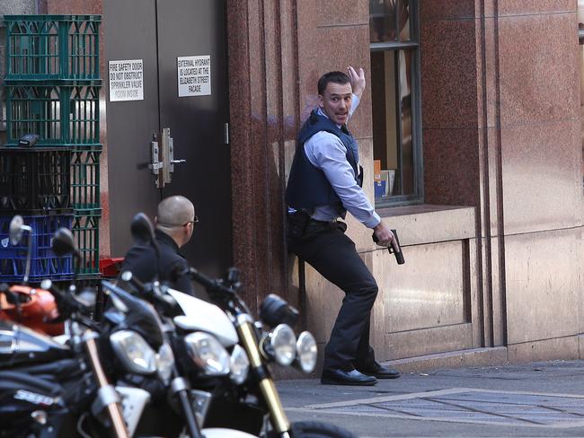 An armed policeman outside the Lindt Cafe soon after Man Monis took his hostages. Picture: Richard Dobson