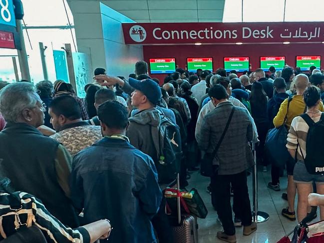 Passengers queue at a flight connection desk at the Dubai International Airport in Dubai on April 17, 2024. Dubai's major international airport diverted scores of incoming flights on April 16 as heavy rains lashed the United Arab Emirates, causing widespread flooding around the desert country. Dubai, the Middle East's financial centre, has been paralysed by the torrential rain that caused floods across the UAE and Bahrain and left 18 dead in Oman on April 14 and 15. (Photo by AFP)